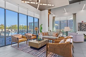 A living room with a large window overlooking a pool and trees.